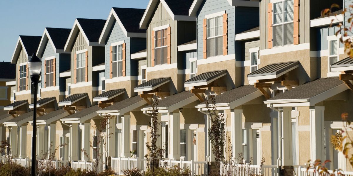 Row of modern condominium homes with uniform design and front porches.