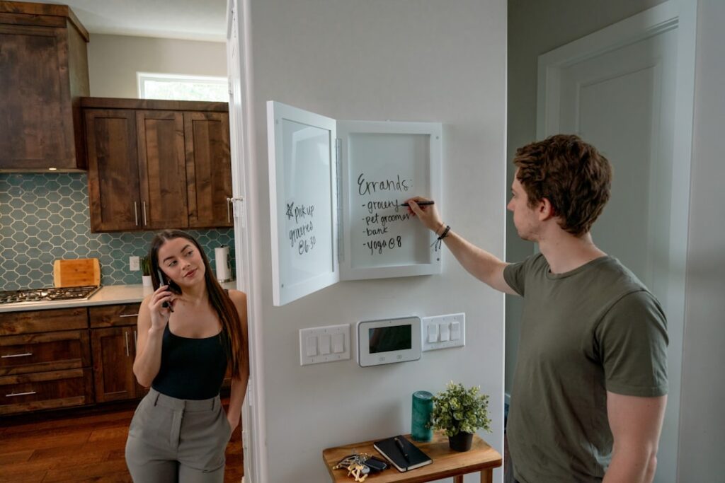 Sleek, wall-mounted smart home control panel displaying icons for lighting, climate, and security in a modern, minimalist ...